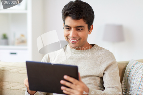 Image of smiling man with tablet pc at home
