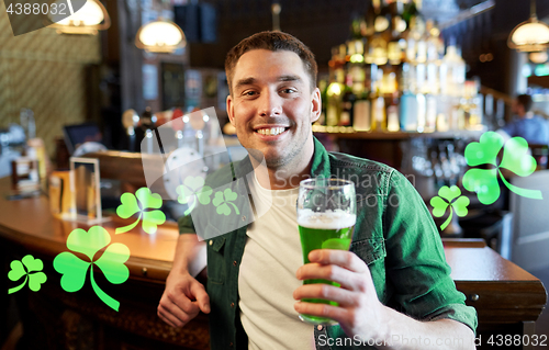 Image of man drinking green beer at bar or pub