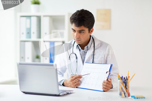 Image of doctor with laptop and cardiogram at clinic