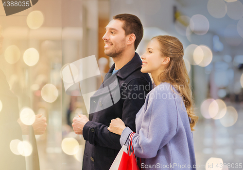 Image of happy young couple with shopping bags in mall