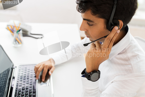 Image of businessman with headset and laptop at office