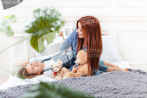 Image of A little cute girl enjoying, playing and creating with toy with mother