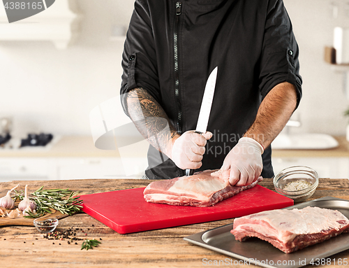 Image of Man cooking meat steak on kitchen