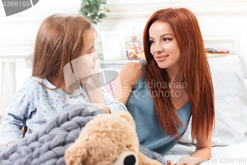 Image of A little cute girl enjoying, playing and creating with toy with mother