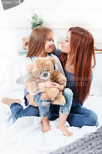 Image of A little cute girl enjoying, playing and creating with toy with mother