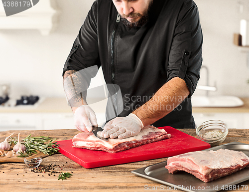 Image of Man cooking meat steak on kitchen