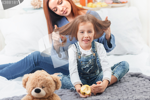 Image of A little cute girl enjoying, playing and creating with toy with mother