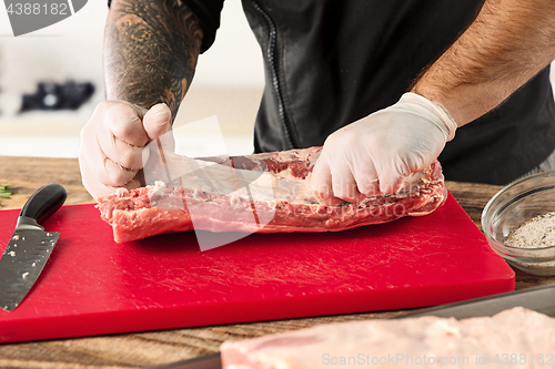 Image of Man cooking meat steak on kitchen