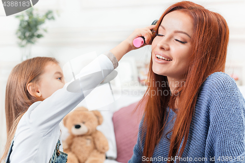 Image of A little cute girl enjoying, playing and creating with toy with mother