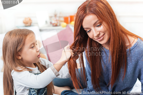 Image of A little cute girl enjoying, playing and creating with mother