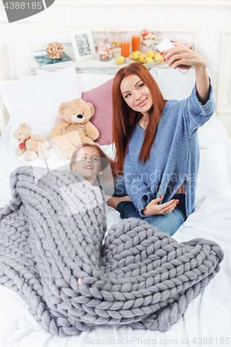 Image of A little cute girl enjoying, playing and creating with toy with mother