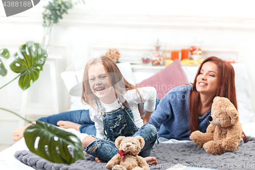 Image of A little cute girl enjoying, playing and creating with toy with mother