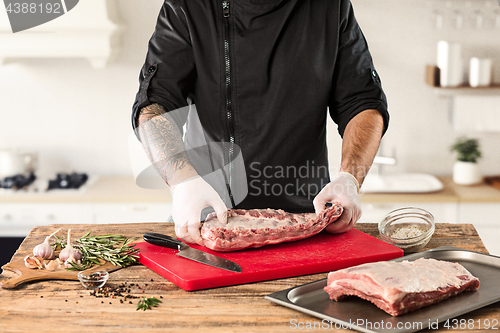 Image of Man cooking meat steak on kitchen