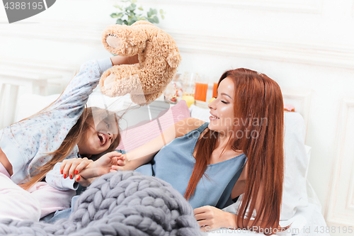 Image of A little cute girl enjoying, playing and creating with toy with mother