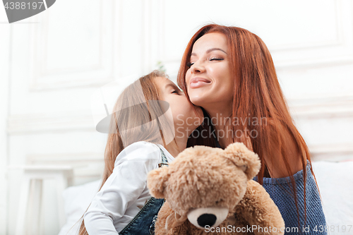 Image of A little cute girl enjoying, playing and creating with toy with mother