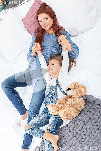 Image of A little cute girl enjoying, playing and creating with toy with mother