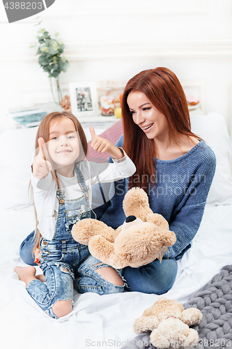 Image of A little cute girl enjoying, playing and creating with toy with mother