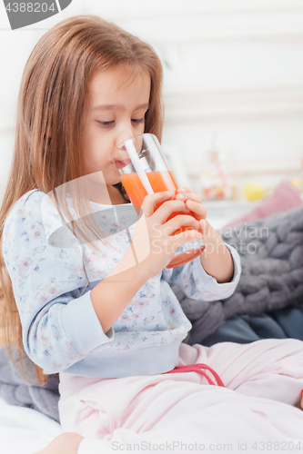 Image of A little cute girl enjoying, playing and creating with juice