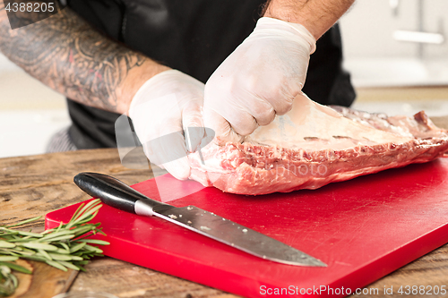 Image of Man cooking meat steak on kitchen