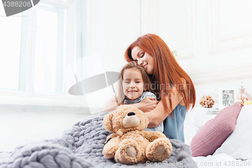 Image of A little cute girl enjoying, playing and creating with toy with mother