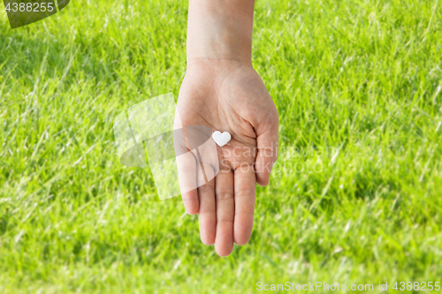 Image of close up of hand holding medicine heart pill