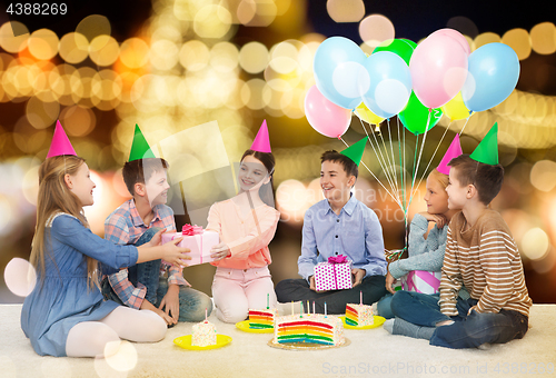 Image of happy children giving presents at birthday party