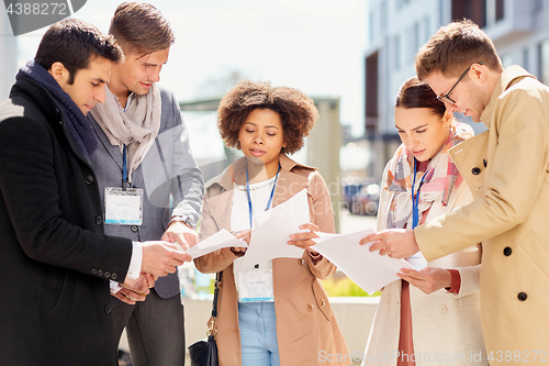 Image of international business team with papers outdoors