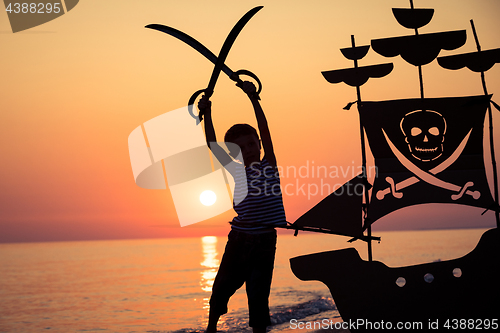 Image of One happy little boy playing on the beach at the sunset time.