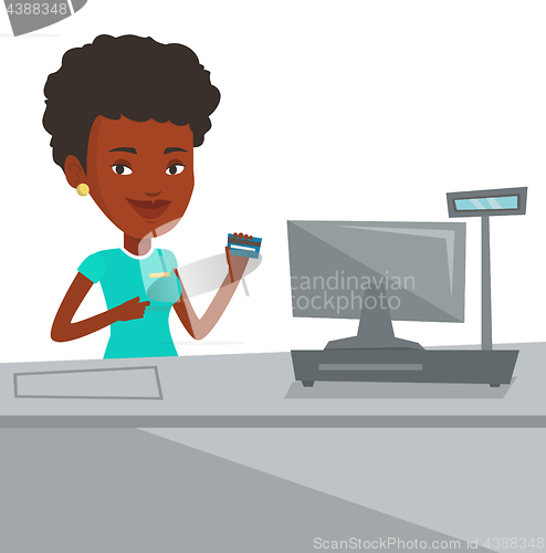 Image of Cashier holding credit card at the checkout.