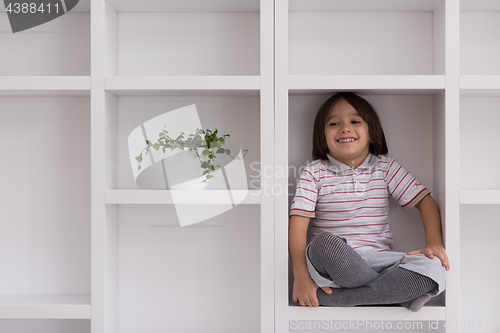 Image of young boy posing on a shelf