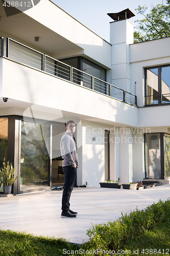 Image of man in front of his luxury home villa