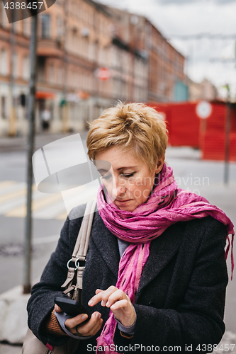 Image of Woman with phone on city street