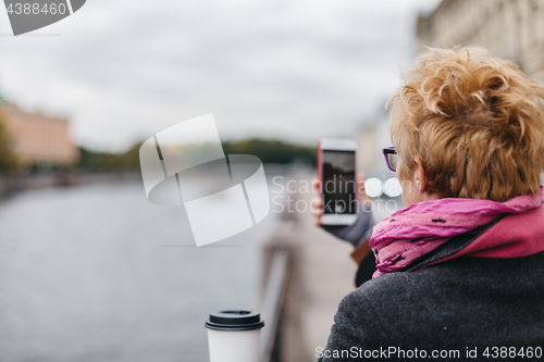 Image of Woman taking shots from waterfront