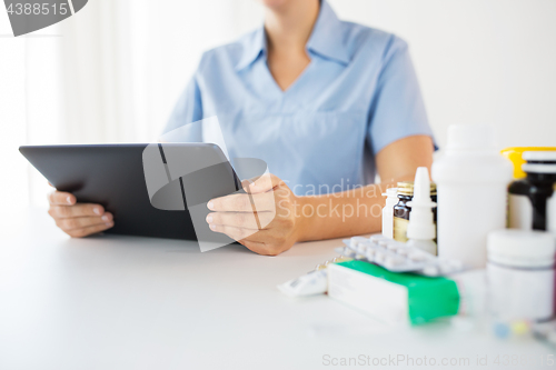 Image of nurse or doctor with medicines and tablet pc