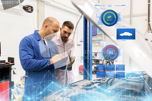 Image of auto mechanic with clipboard and man at car shop