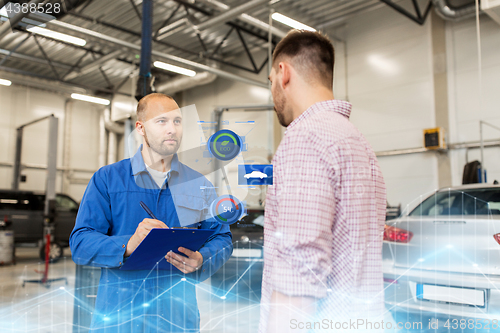 Image of auto mechanic with clipboard and man at car shop