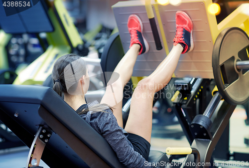 Image of woman flexing muscles on leg press machine in gym