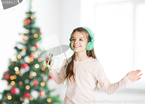 Image of girl with smartphone and headphones at christmas