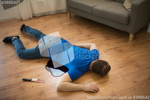 Image of dead man body lying on floor at crime scene