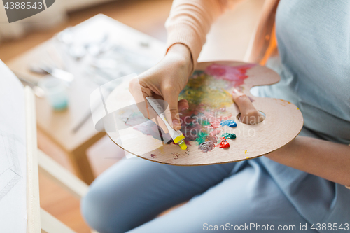 Image of artist applying paint to palette at art studio