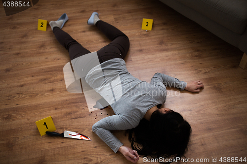 Image of dead woman body lying on floor at crime scene