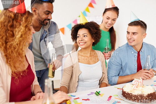 Image of team greeting colleague at office birthday party