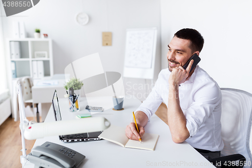 Image of businessman calling on smartphone at office