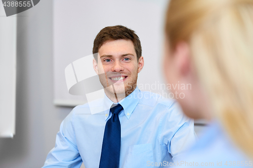 Image of businessman talking to female colleague at office