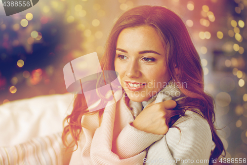 Image of happy young woman with plaid at home for christmas