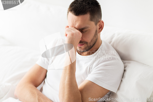 Image of stressed man in bed at home