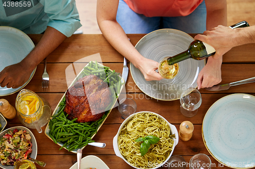 Image of group of people eating and drinking wine