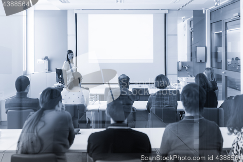 Image of Woman giving presentation in lecture hall at university.