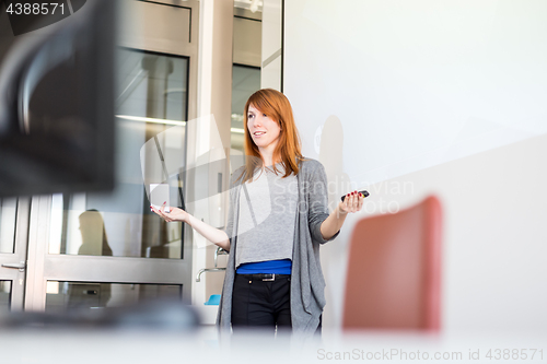 Image of Woman giving presentation in lecture hall at university.