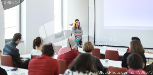 Image of Woman giving presentation in lecture hall at university.